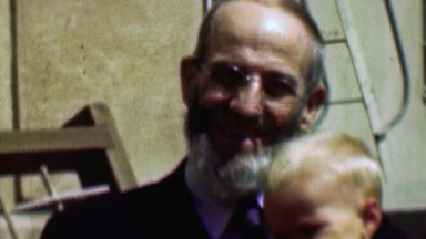 1958: Proud amish style grandfather consoles crying baby boy.