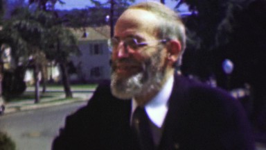 1958: Old bearded amish style man boyishly excited in society.