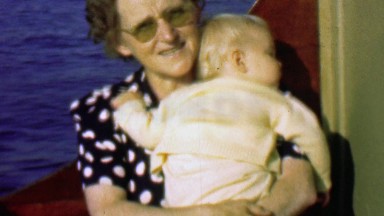 1958: Baby sleeping in grandma's arm on boating trip back home.