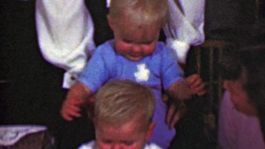 1958: Man stacking family baby towers with available children.