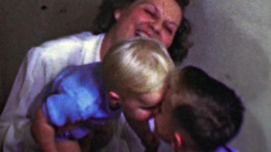 1958: Mom enjoys kid brothers kissing bedtime goodnight.