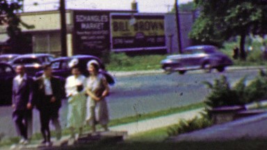1961: Family coming home from church busy classic car traffic.