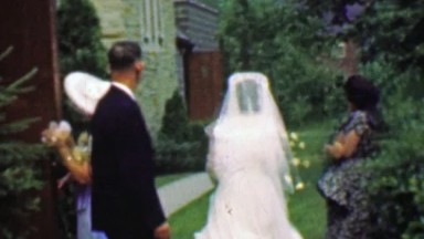 1961: Wedding Party Leaves Church Outside for Reception Photos.