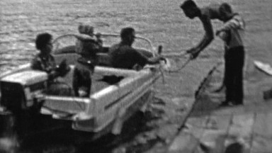 1962: Powerboat landing family helps dock safely.