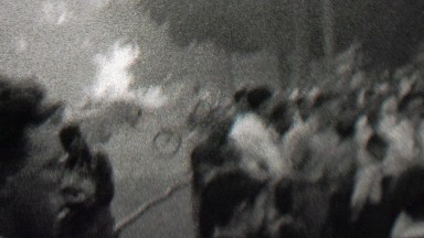 1939: Crowd lookiloos gathers to watch the burning small town building.