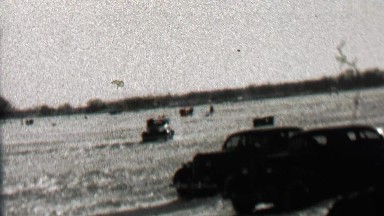 1939: Car driving on frozen lake sliding drift driving on ice surface.