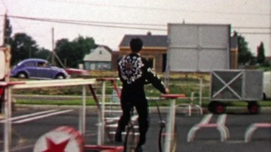 1967: Circus performer driving rear wheel pedal bike around course.