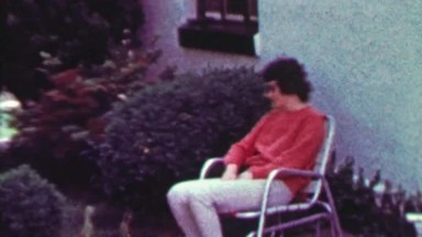 1965: Drug Addict Sunglasses Woman Enjoys Rocking Lawn Chair.