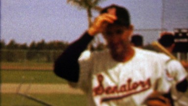 1960: Washington Senators baseball player tips hat to fan photographer.