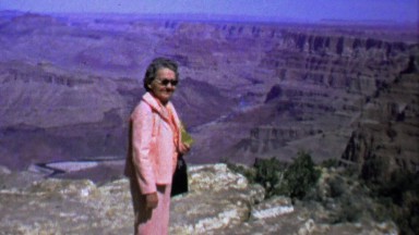 1964: Senior pink pantsuit woman posing grand canyon.