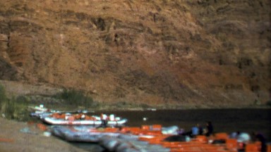 1964: River rafting trip boats ashore while people take lunch.