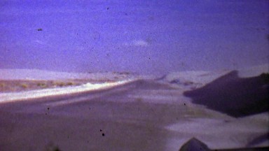 1957: Winter Snow Drift Blows Across Barren Road Landscape