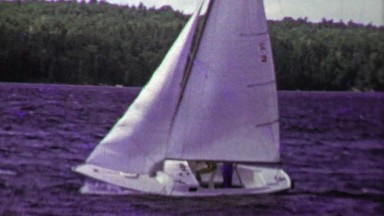 1961: Sailboat full speed ahead on choppy dark blue waters.