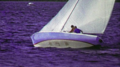 1961: 2 person sailboat tacking into into the wind about to blow over.