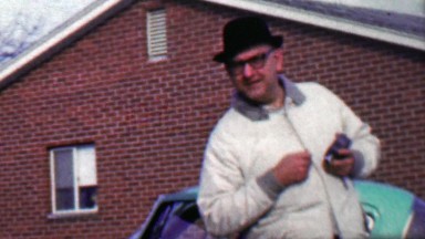 1958: Funny guy pranking camera man staring at hidden camera lens.