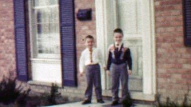 1957: Boy kid brothers calmly leaving fancy house together.
