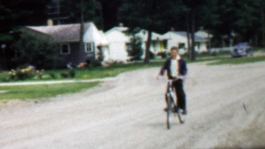 1957: Boy riding bike confidentially coming home from play date.