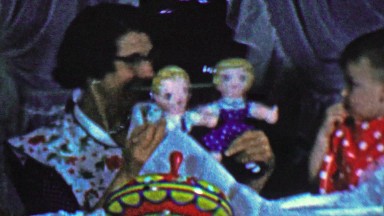 1957: Mom shows cautious baby creepy sibling twin toy dolls.