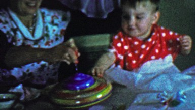 1957: Mom baby spinning top toy gift play learning centrifugal force.