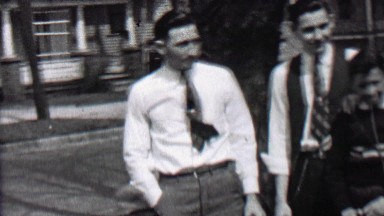 1939: Man Gives Woman Big Hug Joining Family Portrait After Reunion