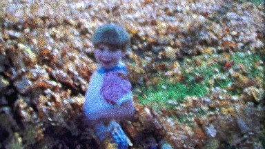 1967: Boy runs autumn leaf pile rural country living style.