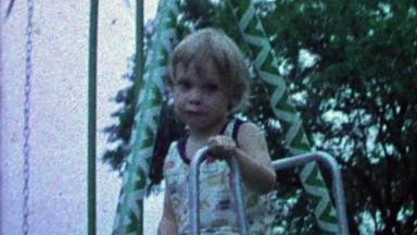 1967: Proud boy climbs to top of playground nervous to get down.