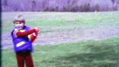 1968: Cute young boy swings wiffle baseball bat runs imaginary bases.