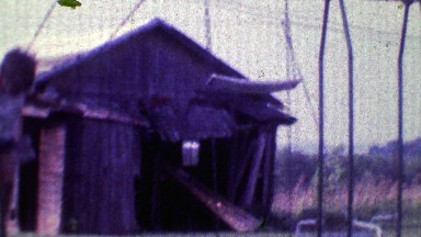 1968: Boy swings hard in family playground with old barn in background.