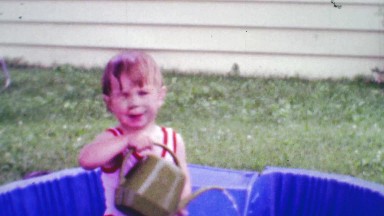 1968: Boy adding water to kiddie pool one gardening bucket at a time.