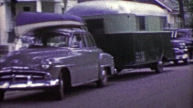 1953: Family truckster car loaded canoe and camping trailer vacation.