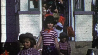1953: Kids leaving house trick r treating dressed hobo homeless bums.