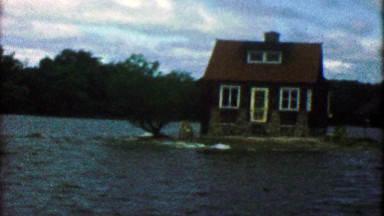 1955: Tiny island house completely surrounded by lake waters.