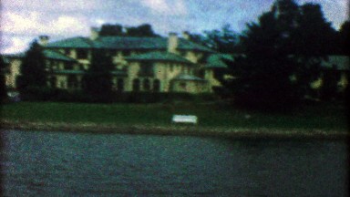 1955: Wealthy lakeside mansion with fancy matching boathouse.