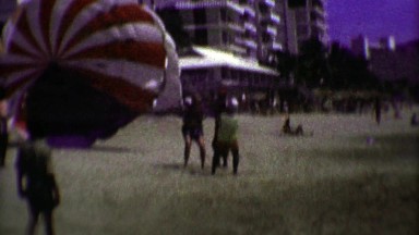 1974: Tourist man parasailing beach launch and safe landing.