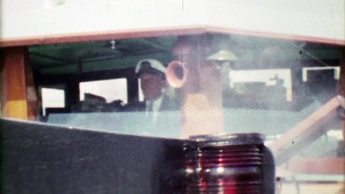 1963: Serious Ship Captain Proudly Steering Past the Haze of Steam.