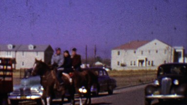 1955: Family Crossing Street Riding Horse as Classic Car Drives By.