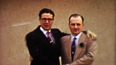 1955: Businessmen Colleagues Awkwardly Embrace During Winter Snowstorm
