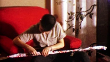 1964: Boy unwraps mysterious Christmas gift it's a fishing pole.