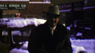 1957: Walls Drugs Store sign downtown city man braves weather.