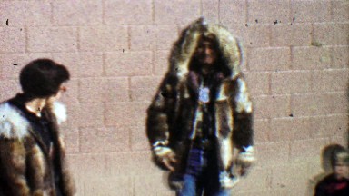 1957: Native American tribal dance fun fur coat for white woman.