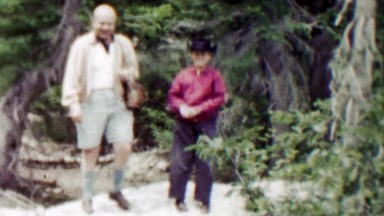1959: Dad son throwing rocks in cowboy hat at cameraman.