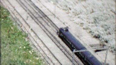 1962: Realistic model train replica crossing bridge exhibit.