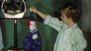 1958: Girl Unsure of Creepy Large Raggedy Anne Style Clown Doll Toy.