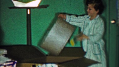 1958: Girl takes out 2 lamps from big box for Christmas gift.