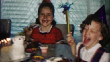 1958: Girl blows out birthday lamb animal cake candle party.