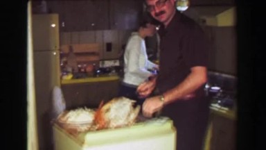 1957: Gluttonous man eating turkey sneaky after Thanksgiving leftovers.