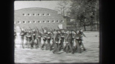1937: Young army men marching training carry rifle guns in tight formation.