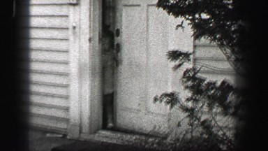 1939: Young girl opens front door runs carelessly towards street escape. ATHENS,
