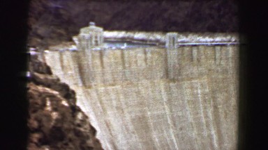 1968: Large stone water dam tan concrete and power generator station. PALM
