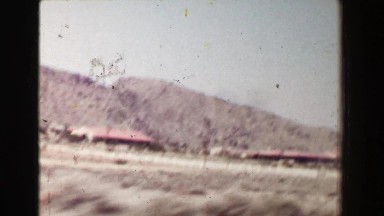 1968: Driving in southwestern USA dry desert landscape passing classic 1940s
